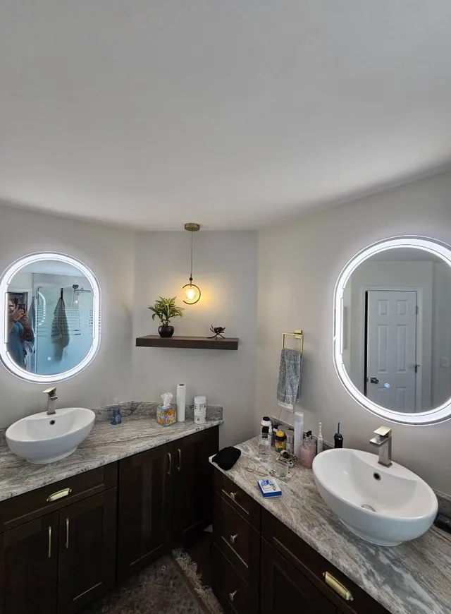 Bathroom with lighted mirrors and a pendant light