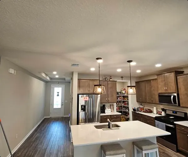 Kitchen and dining area with recessed and pendant lighting